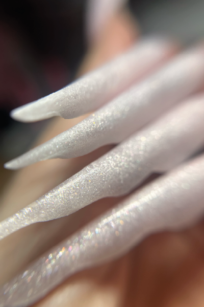 Unhas stiletto longas em tom nude com acabamento iridescente